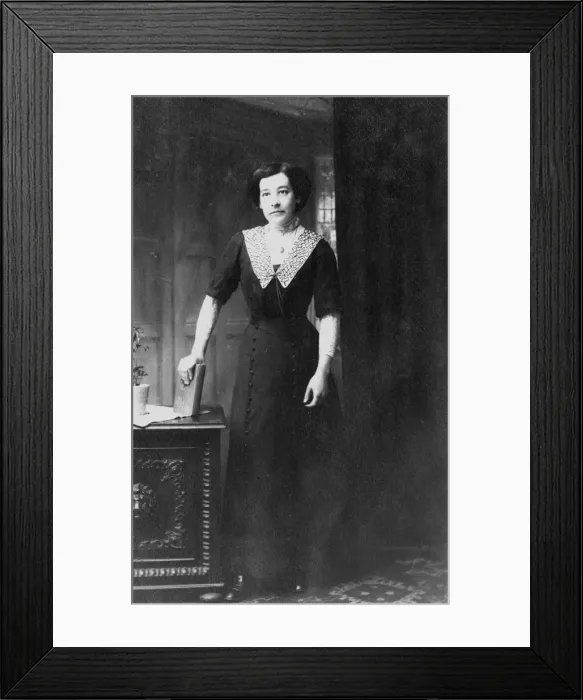 Framed Print : Woman at desk holding a book