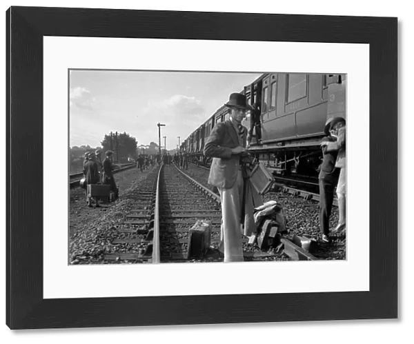 People on a railway track alongside a train