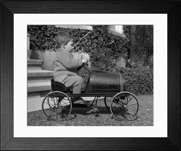 Framed Print : Little boy riding in a toy car Framed Print : Little boy riding in a toy car