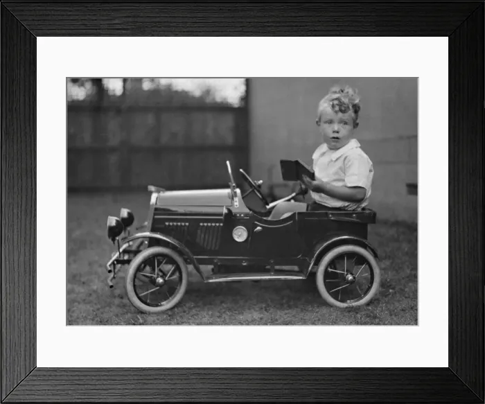 Framed Print : Little boy sitting in a toy car Framed Print : Little boy sitting in a toy car