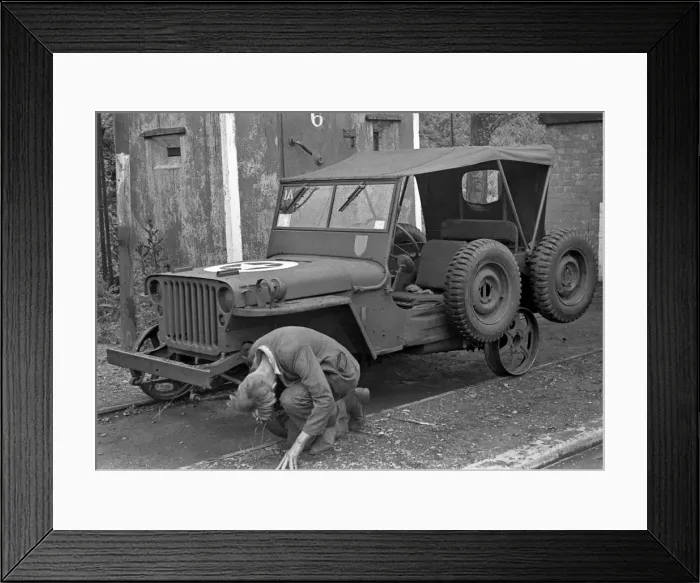 Framed Print : Man repairing a jeep Framed Print : Man repairing a jeep