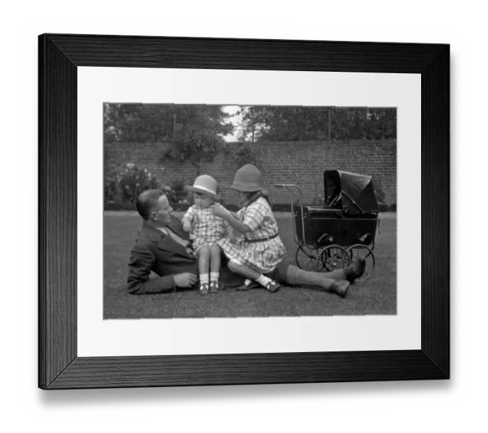Framed Print : Man with two children and a toy pram Framed Print : Man with two children and a toy pram