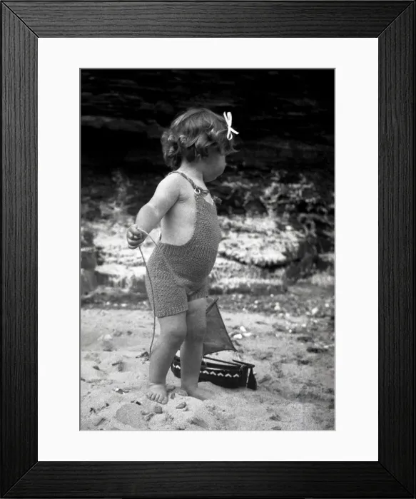 Framed Print : Girl in knitted swimsuit with model boat Framed Print : Girl in knitted swimsuit with model boat