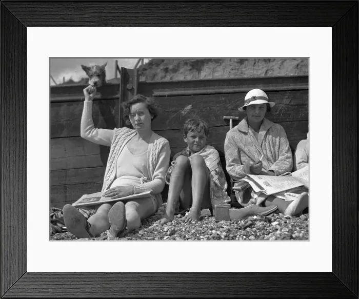 Framed Print : People leaning against a breaker on a beach Framed Print : People leaning against a breaker on a beach