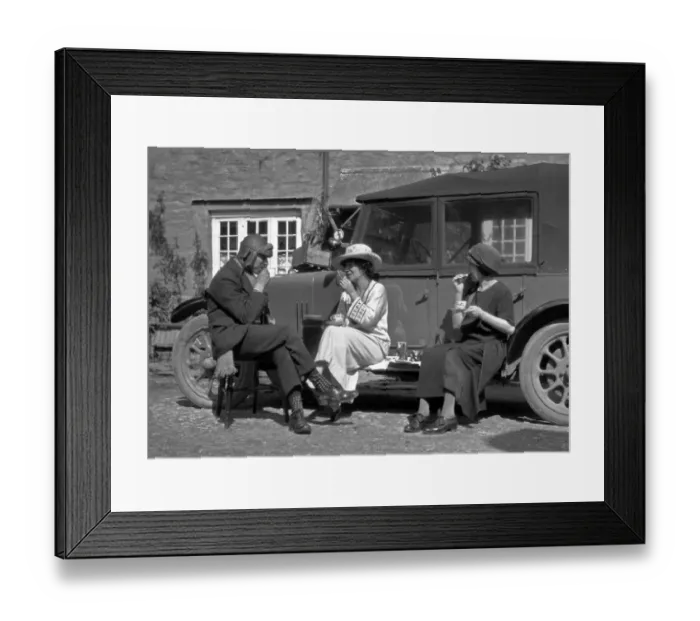 Framed Print : Three people picnicking at the side of a car Framed Print : Three people picnicking at the side of a car