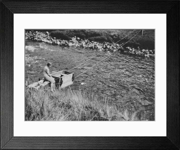 Framed Print : Woman pushing box across river Framed Print : Woman pushing box across river