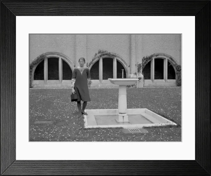 Framed Print : Young woman standing by a fountain Framed Print : Young woman standing by a fountain
