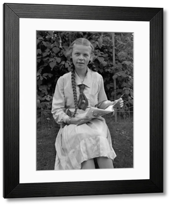 Framed Print : Girl sitting in garden with magazine Framed Print : Girl sitting in garden with magazine