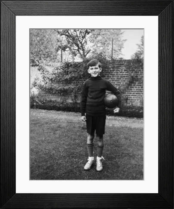 Framed Print : Boy standing in garden with rugby ball, Eltham, London Framed Print : Boy standing in garden with rugby ball, Eltham, London