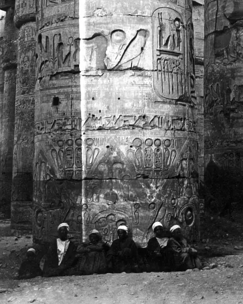 Men sitting at base of column, Karnak, Egypt