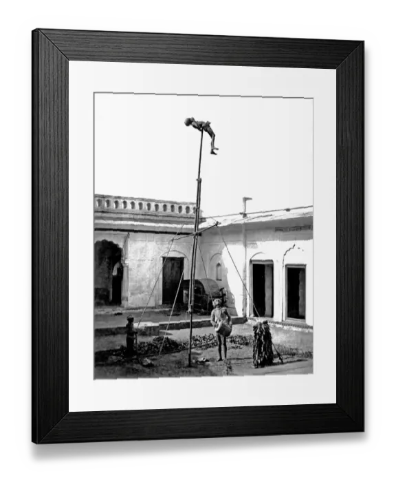 Framed Print : Acrobat on a pole, with drummer below, India Framed Print : Acrobat on a pole, with drummer below, India