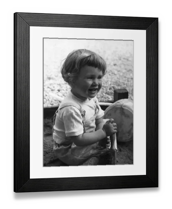 Framed Print : Little girl playing in sandpit