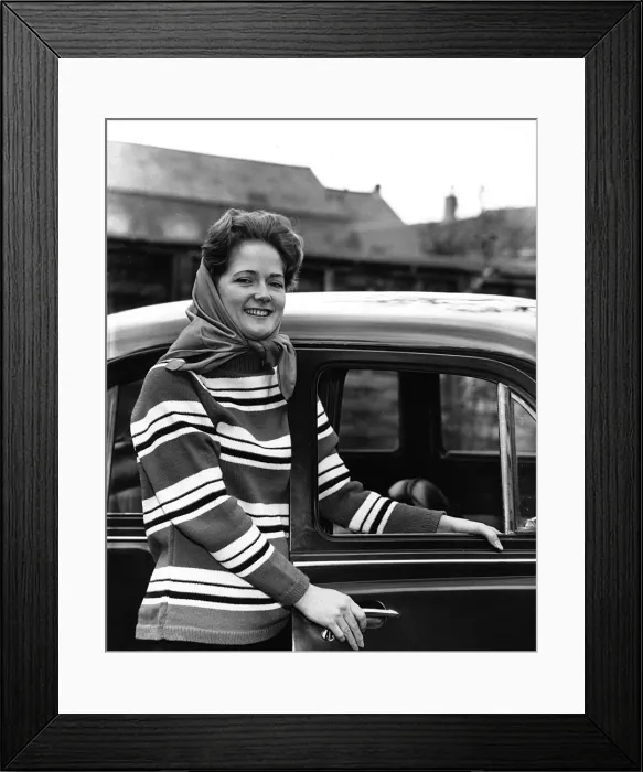 Framed Print : Young woman standing by car Framed Print : Young woman standing by car