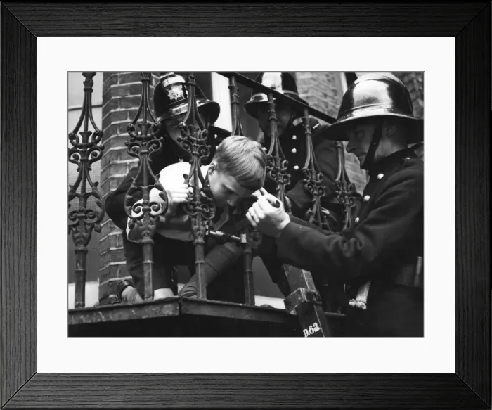 Framed Print : Firefighter using railing expander to release boy Framed Print : Firefighter using railing expander to release boy