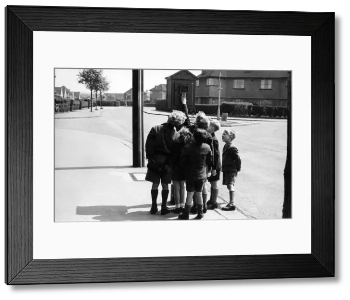 Framed Print : Street telephone fire alarm with group of children Framed Print : Street telephone fire alarm with group of children