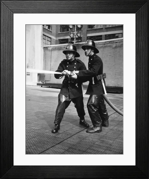Framed Print : Firefighters taking part in a hose training drill