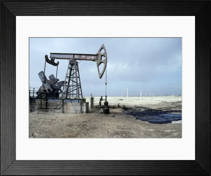 Framed Print : A typical oil-pump on an oil-well with a puddle Framed Print : A typical oil-pump on an oil-well with a puddle