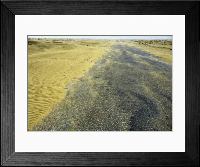 Framed Print : Sand dunes in a wind - Karakum desert encroach on a road Framed Print : Sand dunes in a wind - Karakum desert encroach on a road