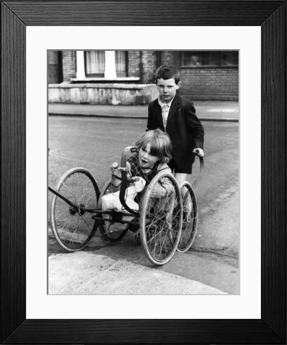 Framed Print : Girl and boy with pram wheels, Balham, SW London Framed Print : Girl and boy with pram wheels, Balham, SW London