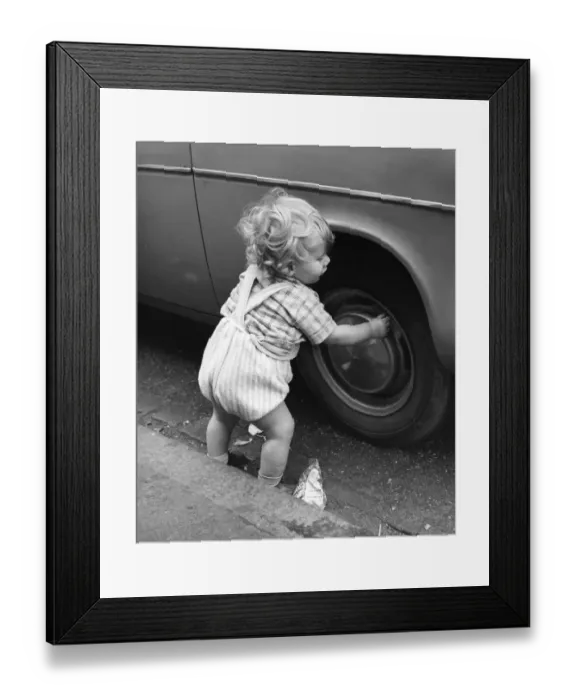Framed Print : Toddler playing with car tyre, Balham, SW London