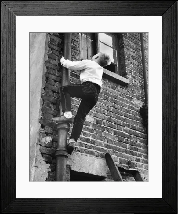 Framed Print : Boy climbing drainpipe on a Balham house, SW London