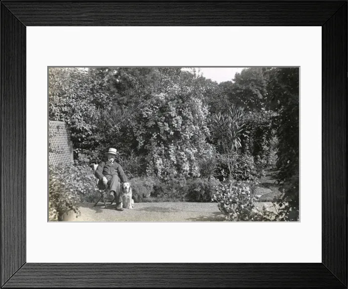 Framed Print : Man in deckchair with pet dog Framed Print : Man in deckchair with pet dog