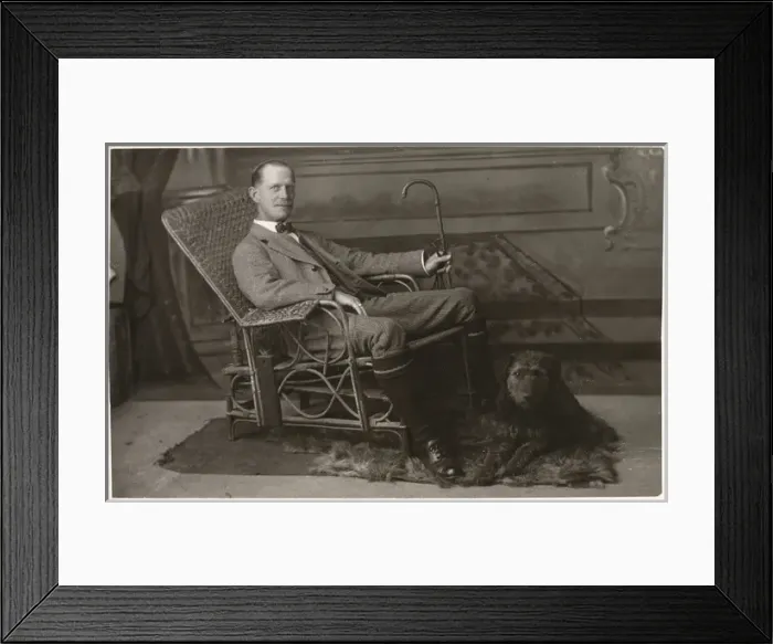 Framed Print : Man in wickerwork chair with pet dog Framed Print : Man in wickerwork chair with pet dog