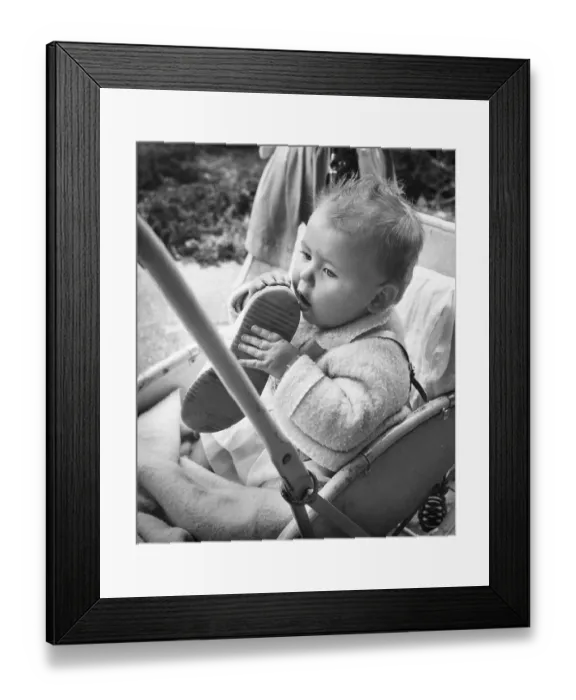 Framed Print : Baby holding shoe in Balham, SW London Framed Print : Baby holding shoe in Balham, SW London