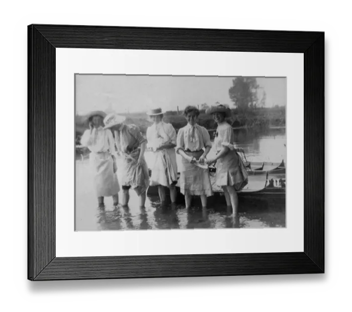 Framed Print : Women paddling in water by rowing boat Framed Print : Women paddling in water by rowing boat