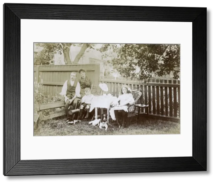 Framed Print : Family of four and a dog in a garden Framed Print : Family of four and a dog in a garden