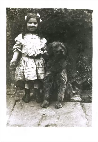 Little girl with a dog in a garden