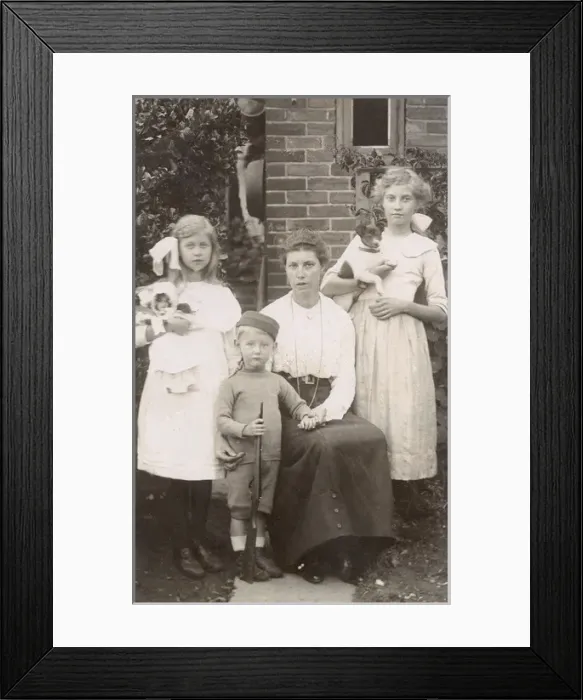 Framed Print : Family of four with a dog and a doll in a garden Framed Print : Family of four with a dog and a doll in a garden