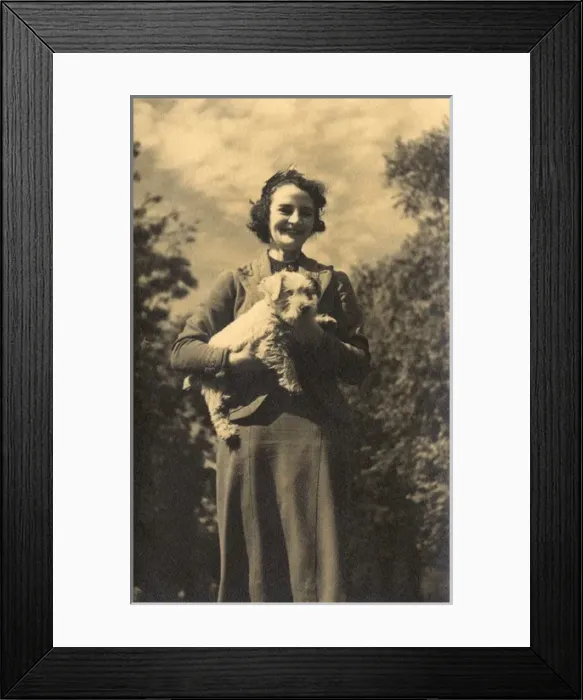 Framed Print : Woman holding a dog in a garden Framed Print : Woman holding a dog in a garden