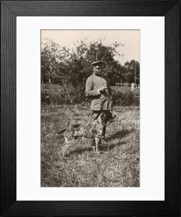 Framed Print : Man in uniform with a dog in a field, Germany Framed Print : Man in uniform with a dog in a field, Germany