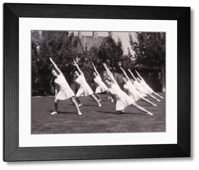 Framed Print : Seven perform stretches in garden Framed Print : Seven perform stretches in garden
