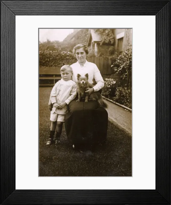 Framed Print : Woman and boy with a dog in a garden