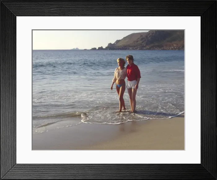 Framed Print : Young couple walking along a beach, West Country Framed Print : Young couple walking along a beach, West Country