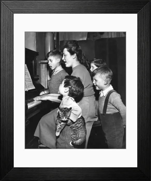 Framed Print : Family and cat practising Christmas carols at the piano Framed Print : Family and cat practising Christmas carols at the piano