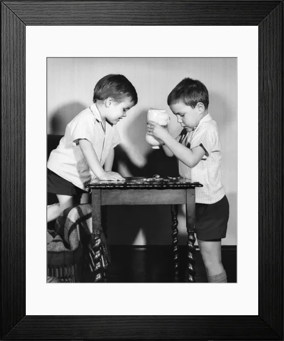 Framed Print : Two boys emptying a piggy bank Framed Print : Two boys emptying a piggy bank