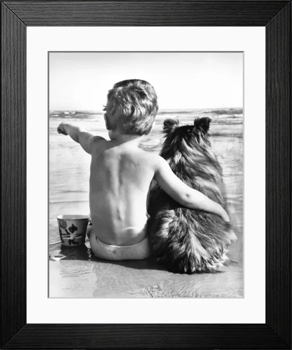 Framed Print : A boy and his pet dog sitting on a beach Framed Print : A boy and his pet dog sitting on a beach