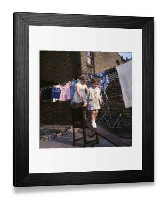 Framed Print : Two girls playing on planks, Balham, SW London Framed Print : Two girls playing on planks, Balham, SW London
