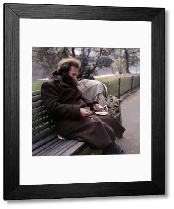 Framed Print : Man feeding sparrow in a Balham park, SW London Framed Print : Man feeding sparrow in a Balham park, SW London