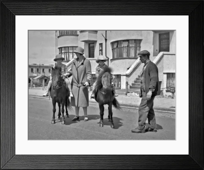 Framed Print : Two children riding ponies in a street Framed Print : Two children riding ponies in a street