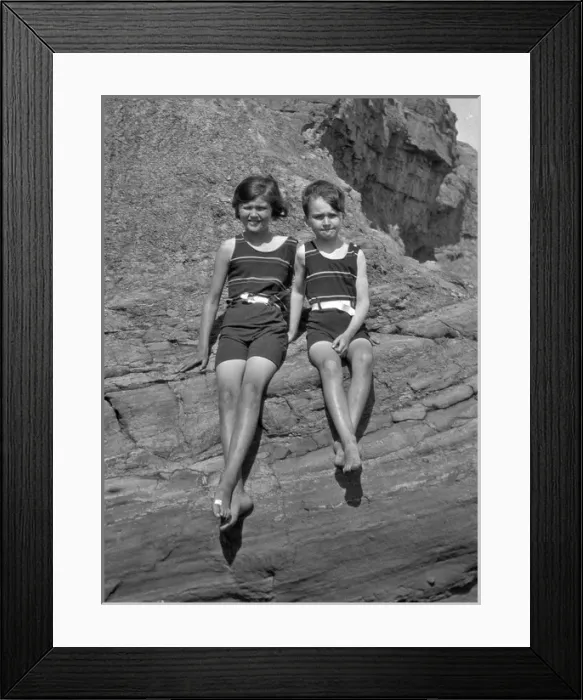 Framed Print : Girl and boy sitting on rocks at the seaside Framed Print : Girl and boy sitting on rocks at the seaside