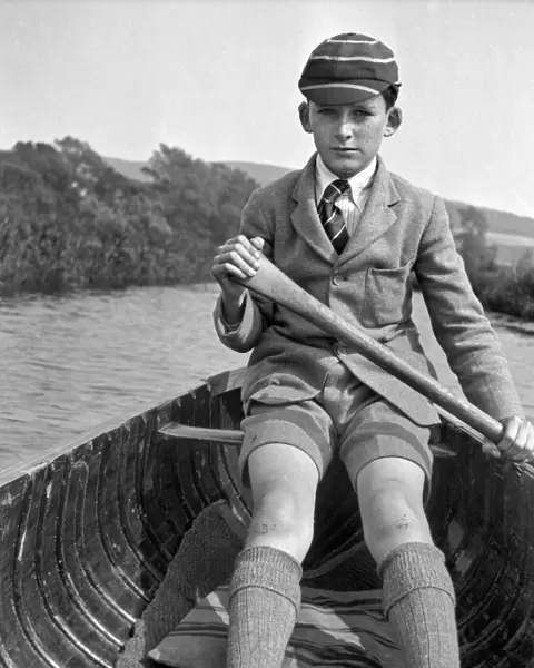 Boy in school uniform rowing a boat