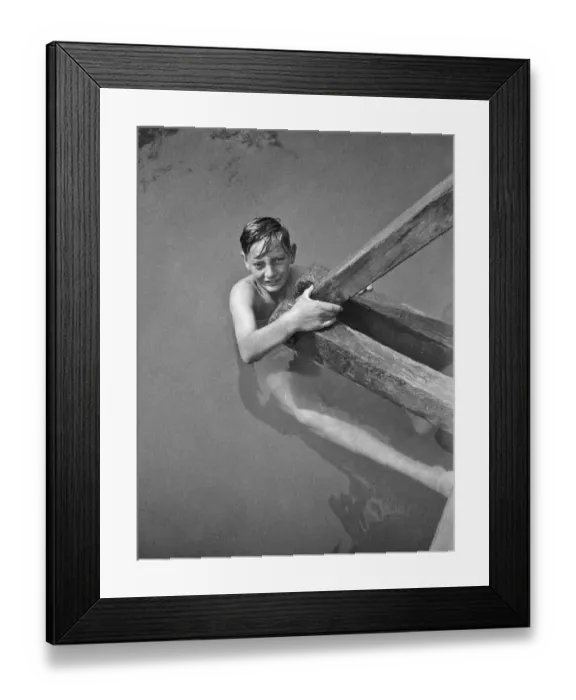 Framed Print : Boy swimmer holding on to wooden beam Framed Print : Boy swimmer holding on to wooden beam