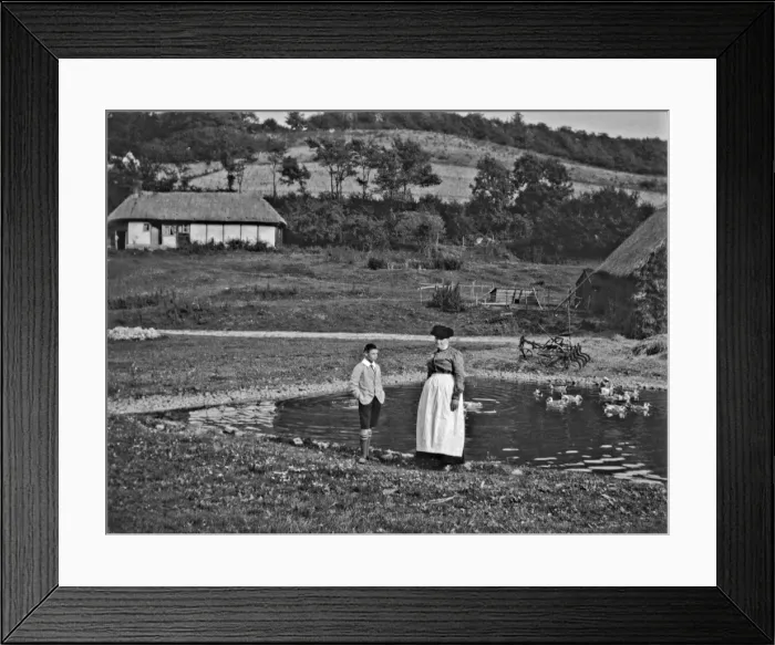 Framed Print : Woman and boy standing by a duckpond Framed Print : Woman and boy standing by a duckpond