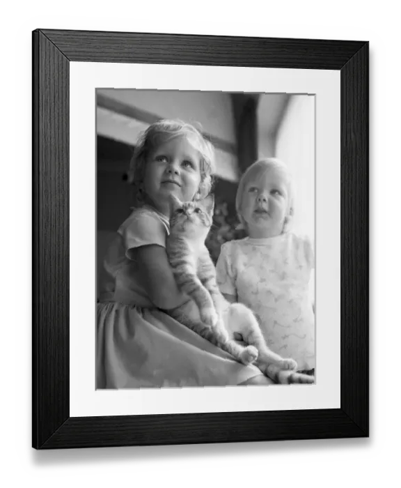 Framed Print : Two young sisters and their pet cat Framed Print : Two young sisters and their pet cat