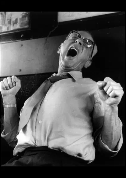Man yawning and stretching on a train