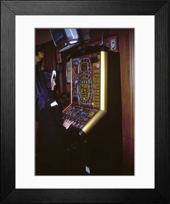 Framed Print : Nun playing on a fruit machine Framed Print : Nun playing on a fruit machine